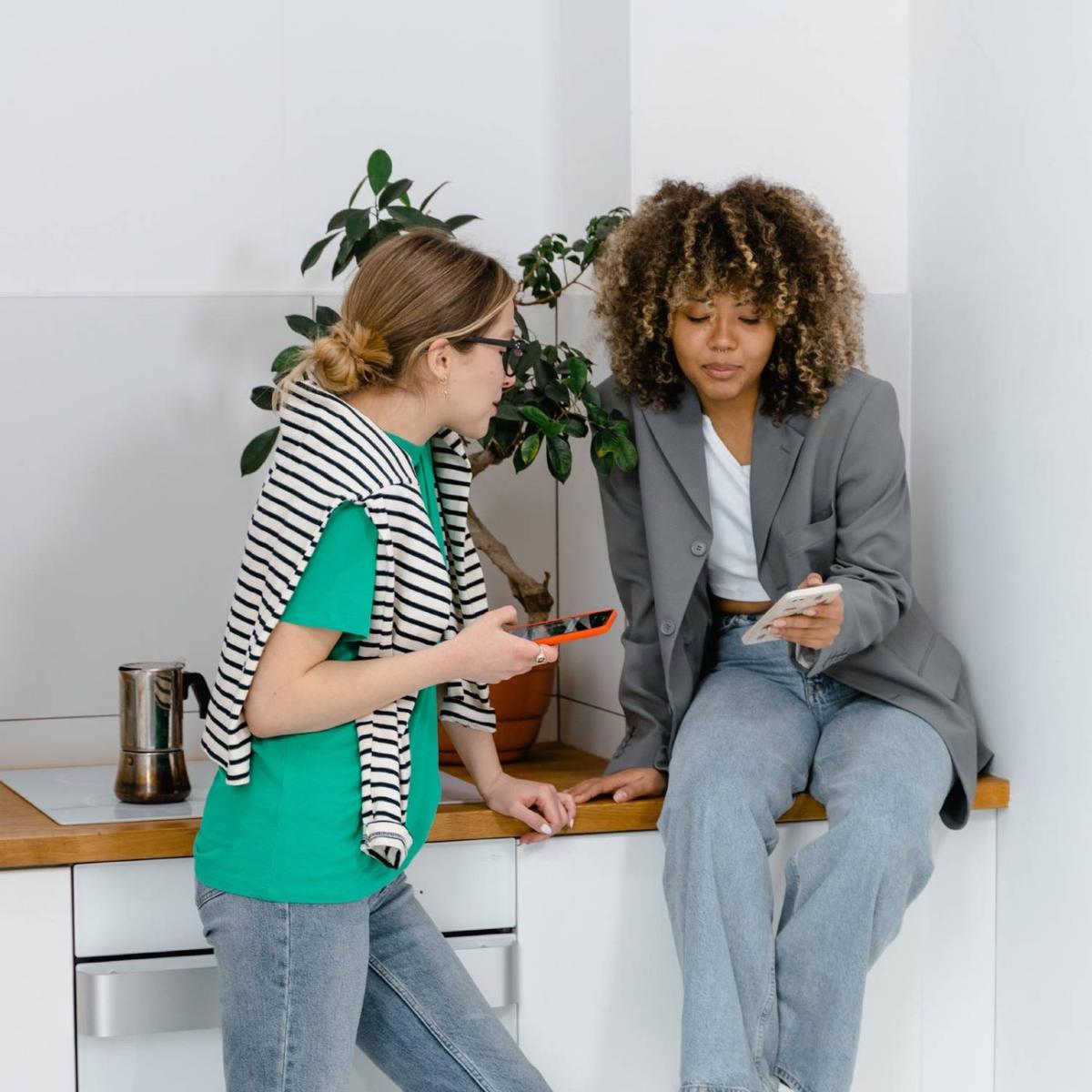 Two colleagues reviewing work on their phones