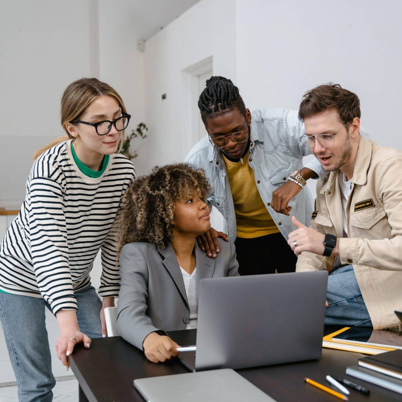 Marketing team working together around a laptop